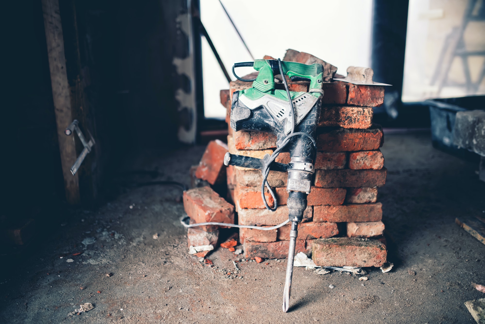 Construction tool, industrial jackhammer with demolition debris and bricks